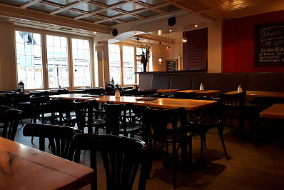 Cafe Konkret in Bochum. Das Bild zeigt den Innenraum mit Tischen und Stühlen. 